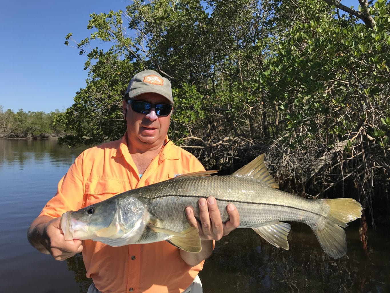 a fisherman with a snook caught in naples